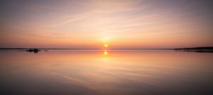 When God is silent KJV — sunrise over calm water symbolizing peace in the silence.
